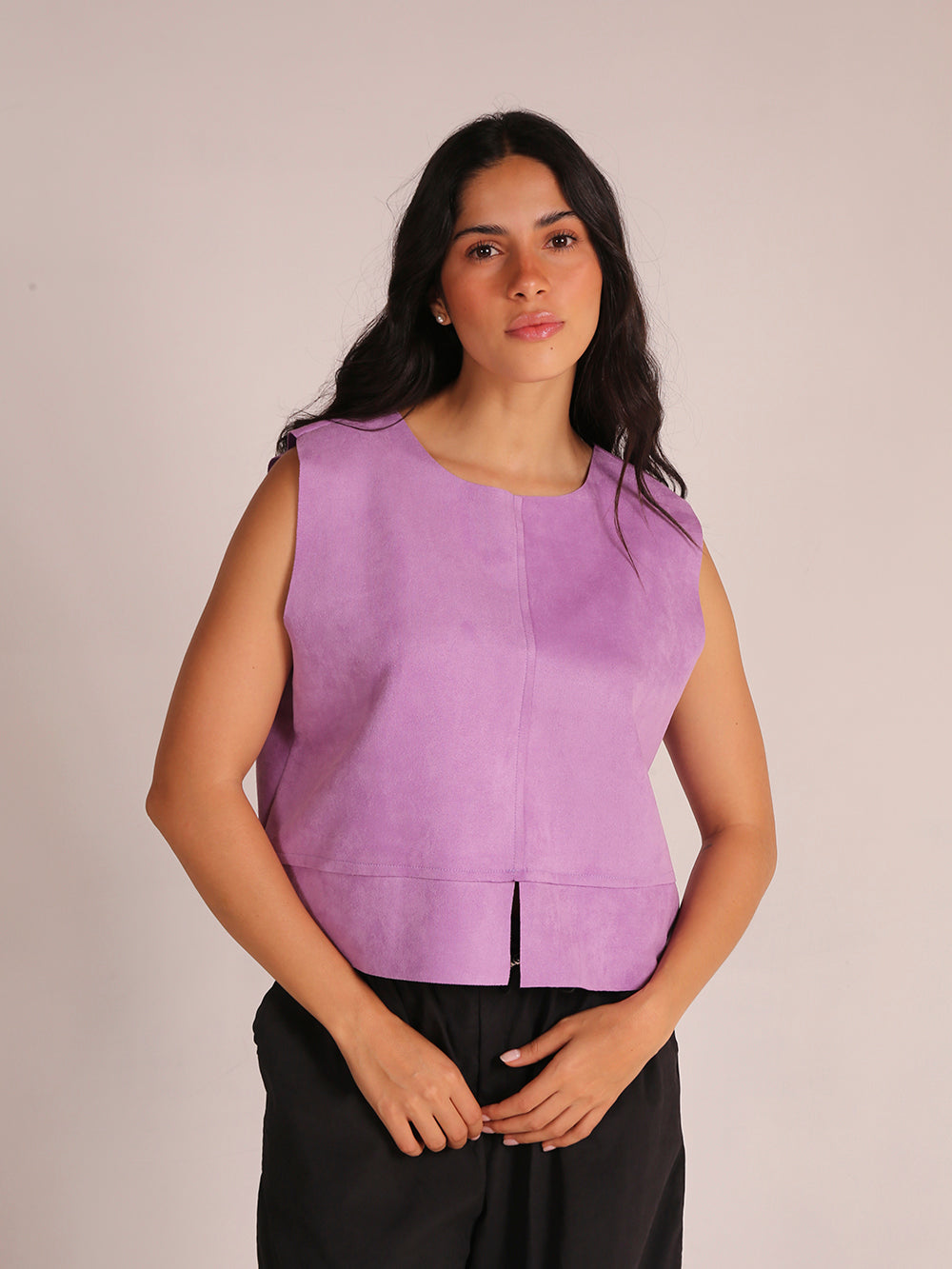 Top sin mangas elaborado en tela de gamuza sintética, con un elegante cuello en V. La prenda es liviana y presenta una silueta recta, ofreciendo comodidad y estilo. Ideal para combinar con pantalones altos, este top es perfecto para ocasiones casuales o salidas elegantes.